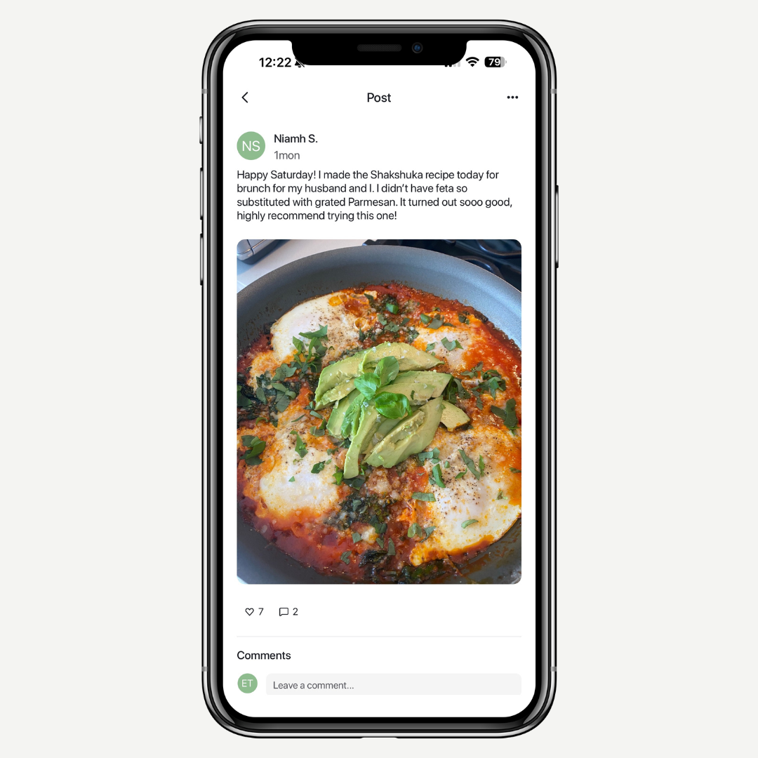 Phone displaying a recipe post with Shakshuka dish on a white background