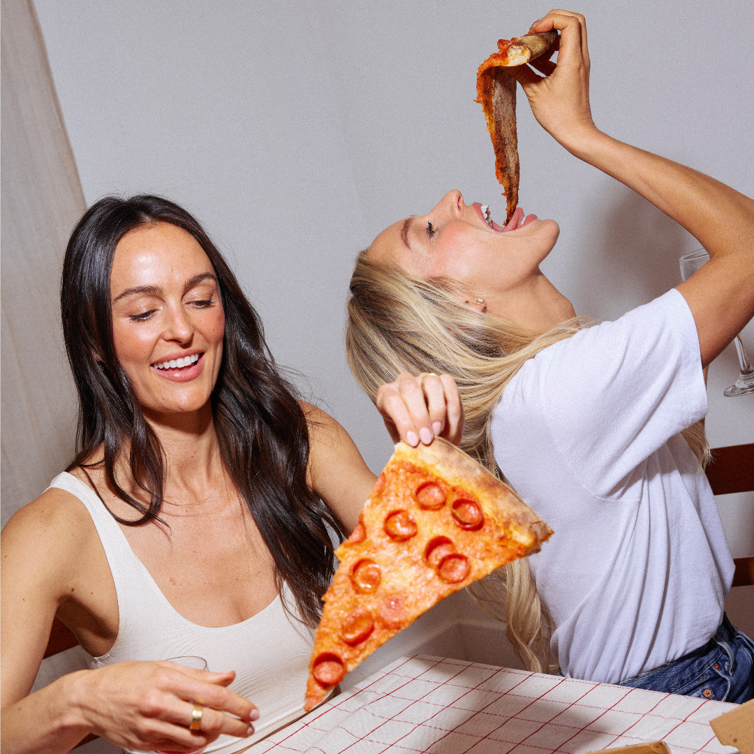 Megan and Katy enjoying slices of pizza together.