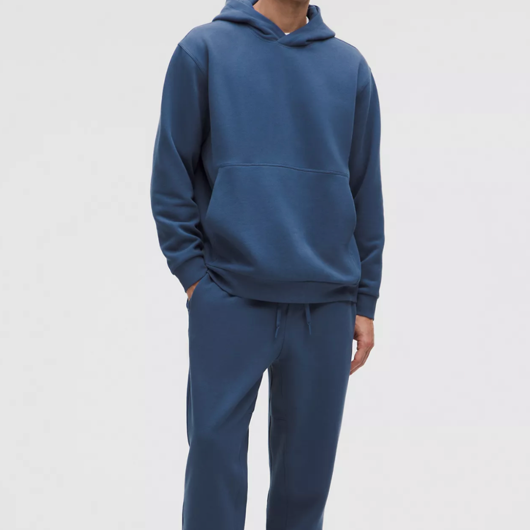 Person wearing a blue hoodie and sweatpants on a white background
