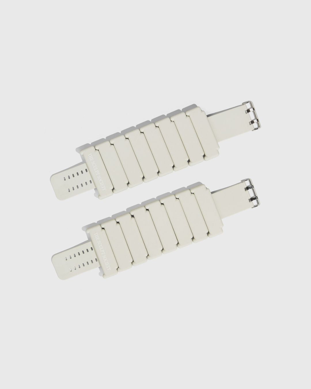 Two white ankle weights on a light background