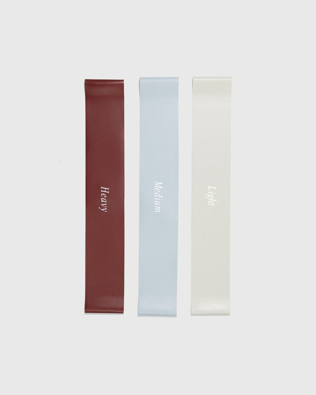 3 rubber workout bands in 3 weights heavy, medium, and light laying flat