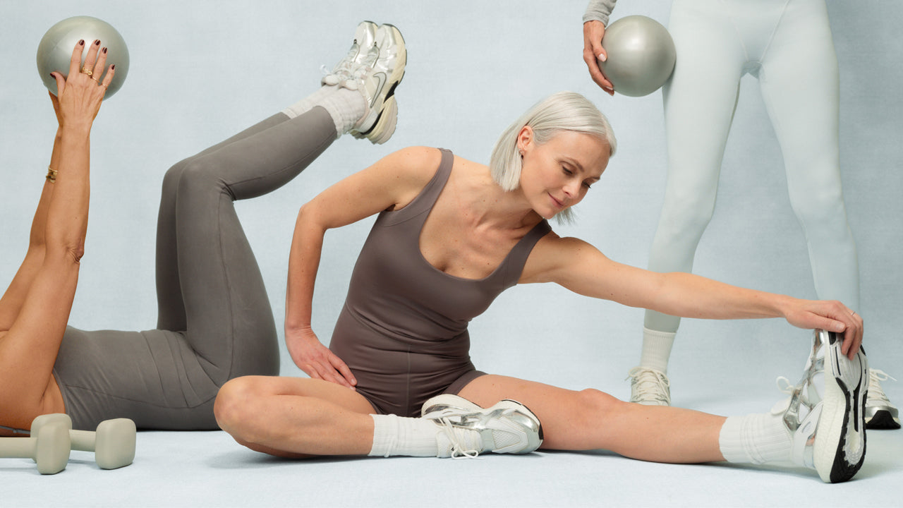 Woman exercising with dumbbells on a light gray background